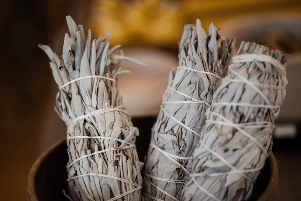 dried white sage bundles in a bowl